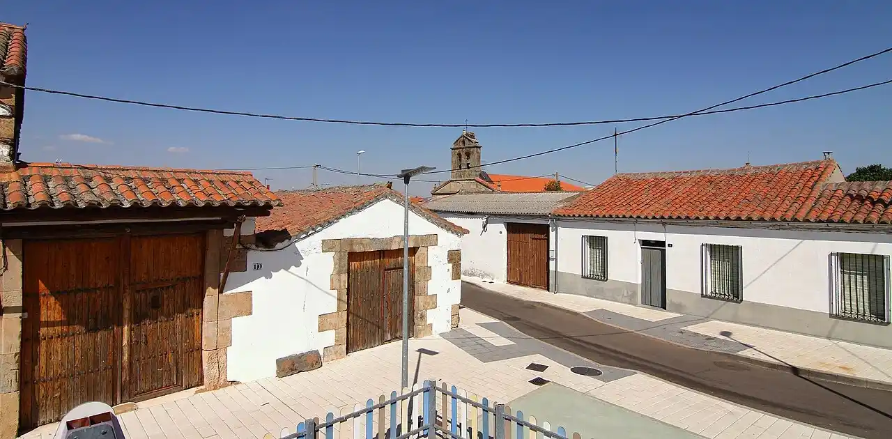 Mudanzas en Doñinos de Salamanca 8 Calle de casas blancas con tejados de teja roja y una espadaña al fondo